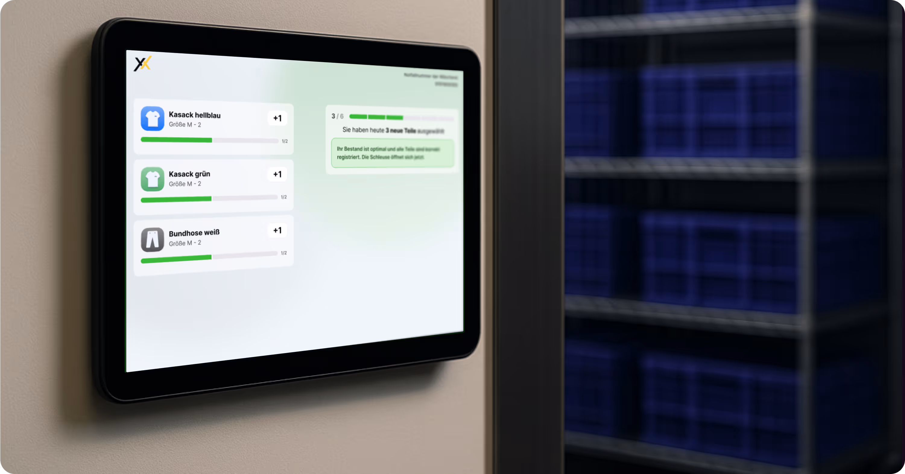 A digital wall display running the Texxeo software, showing a clear stock view of workwear including tunics in several colours and trousers