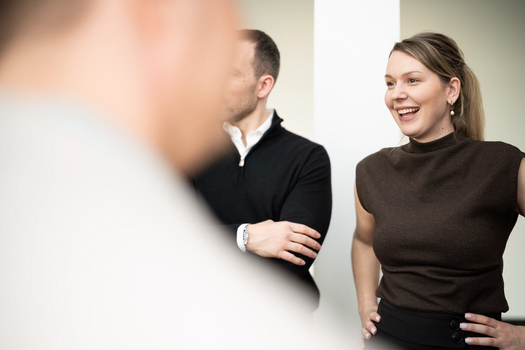 Nadia Wiegand in conversation, laughing, two other people in a bright room behind her